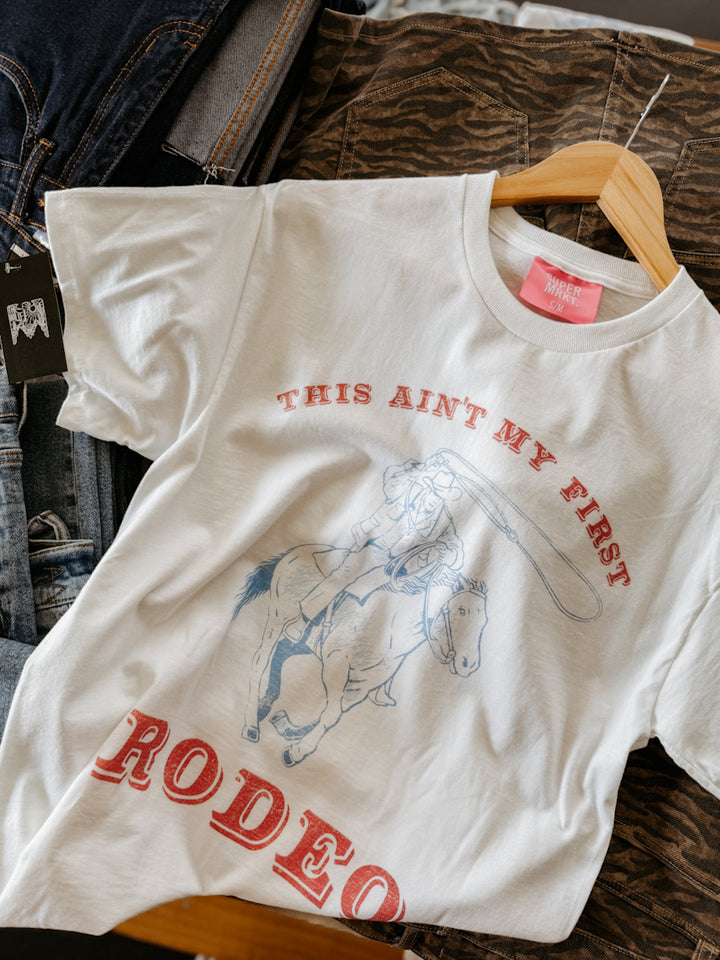 White t-shirt with red text and graphic of a bull on a hanger.