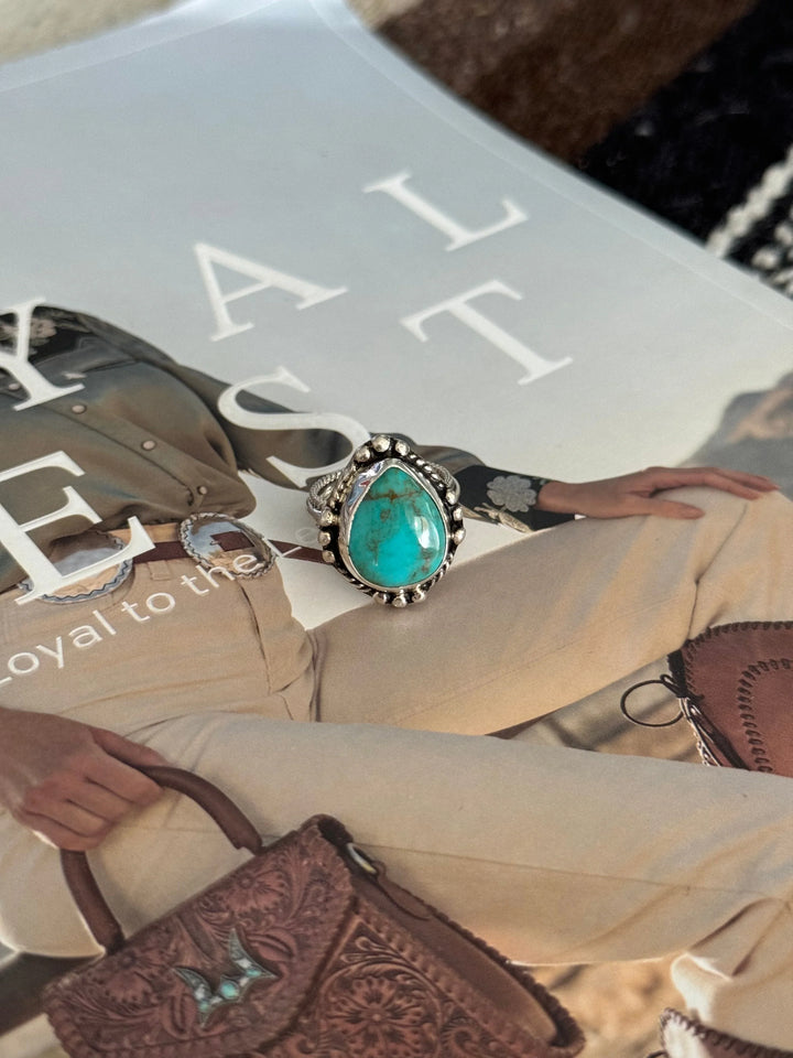 Turquoise western boho ring with silver detailing on magazine featuring western outfit