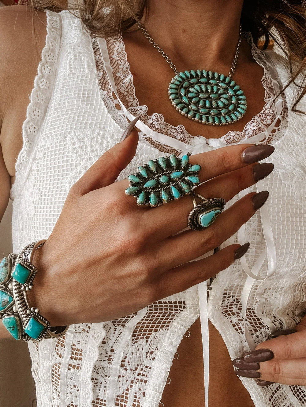 Woman wearing boho western turquoise jewelry set with lace white top, showcasing necklace, ring, and bracelet.