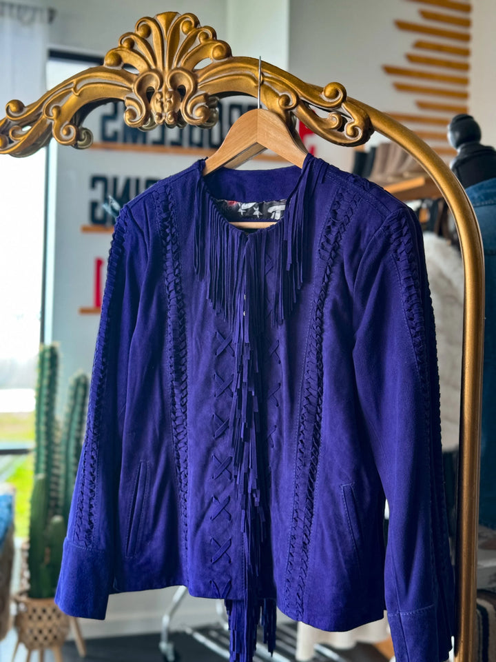 Purple suede fringe western jacket with braided details hanging on ornate hanger