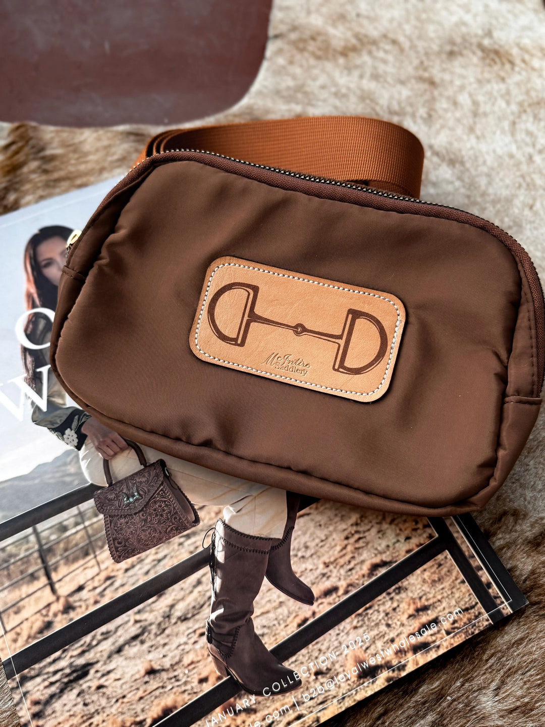 Brown leather bag with a brand logo on a textured surface