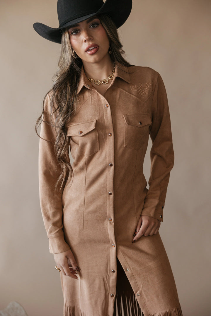 Woman in western suede shirt dress with fringe, cowboy hat, and gold jewelry, boho cowgirl style