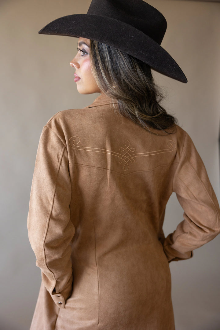 Woman in western brown suede jacket and black cowboy hat, boho cowgirl fashion