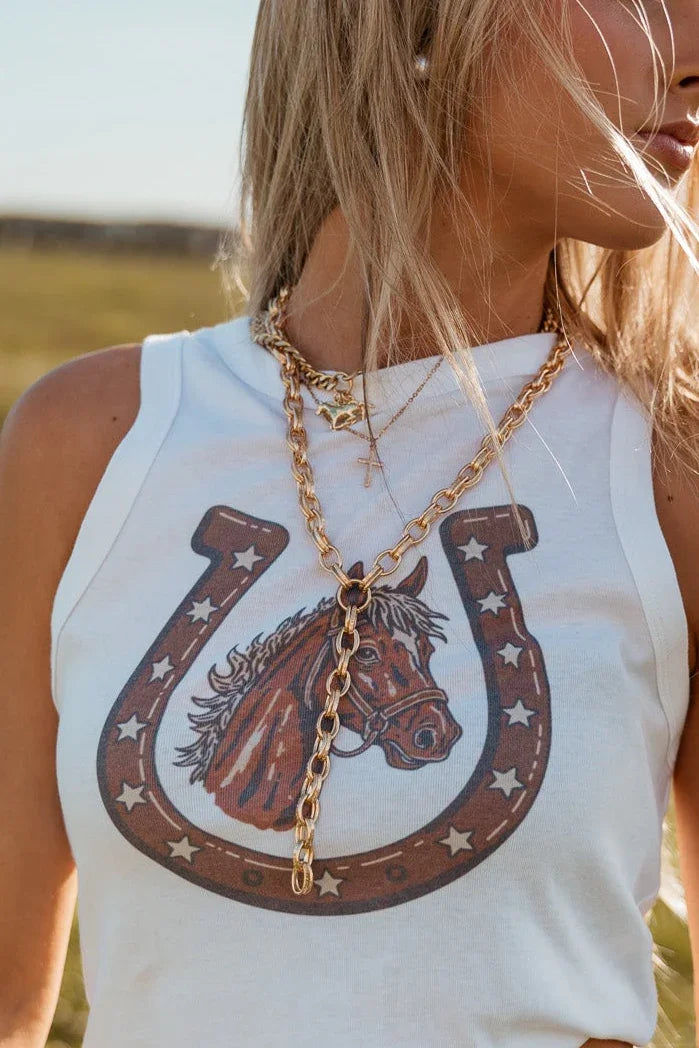 Layered gold chain necklace styled with western graphic tank