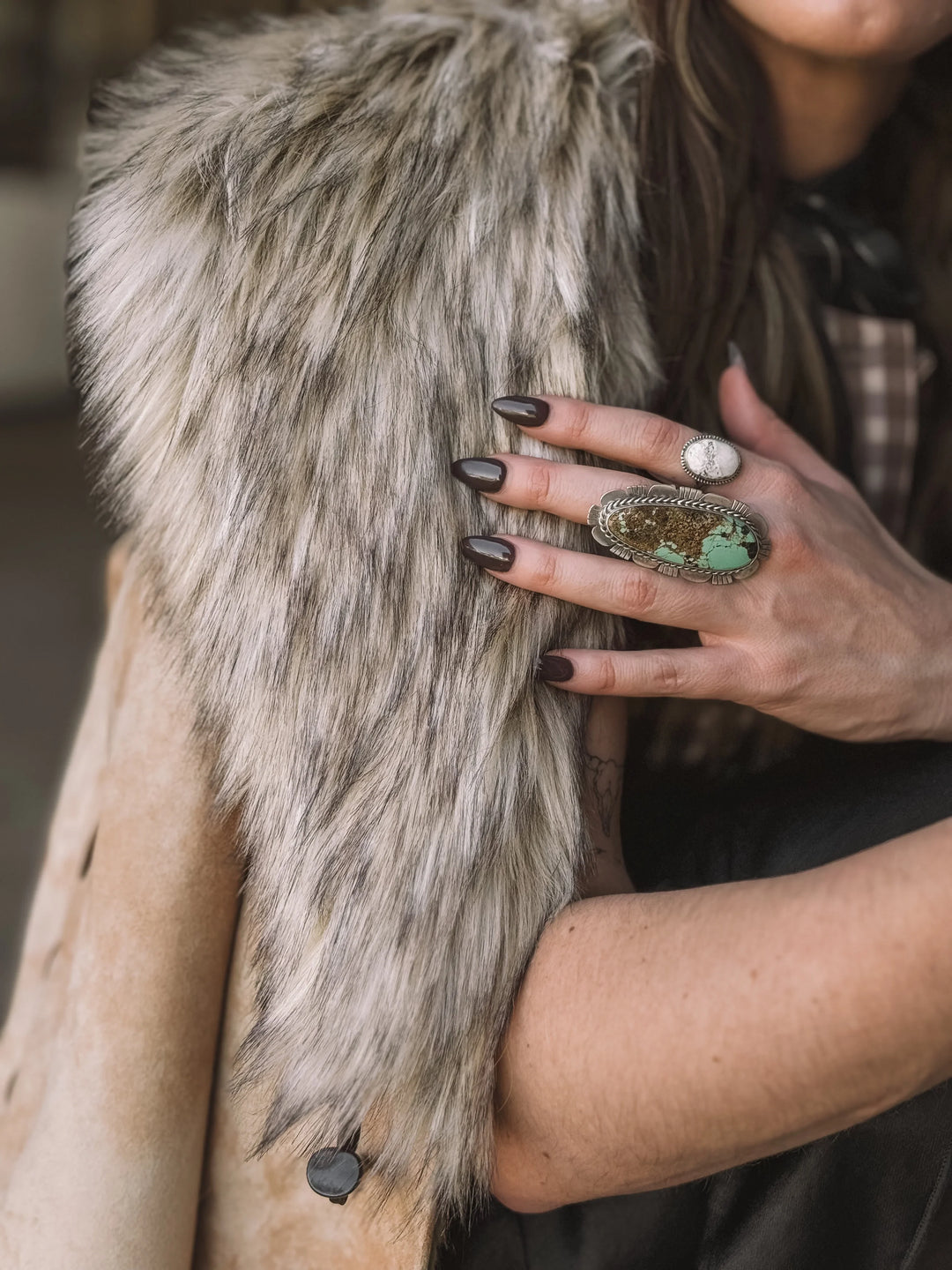 Woman wearing faux fur western vest and turquoise statement ring, western boho style