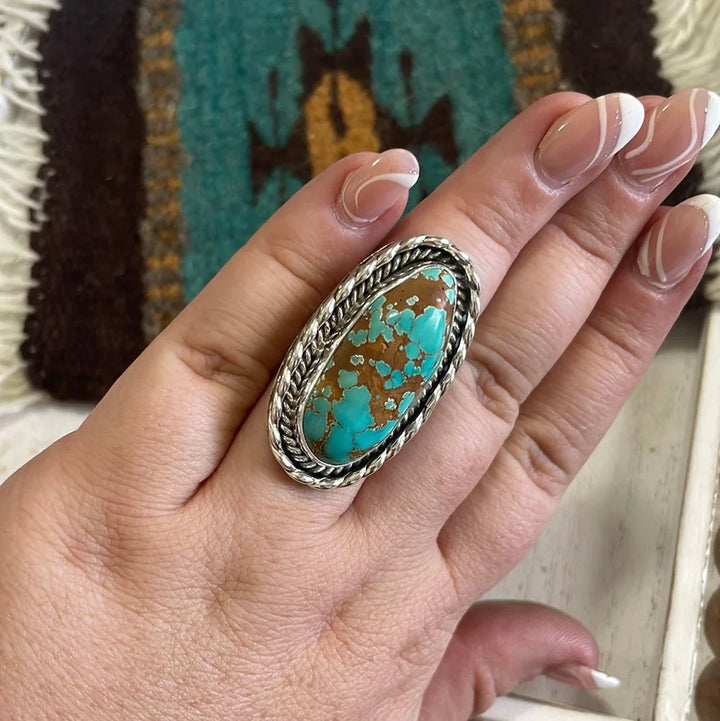 Hand wearing large oval turquoise and silver western boho statement ring