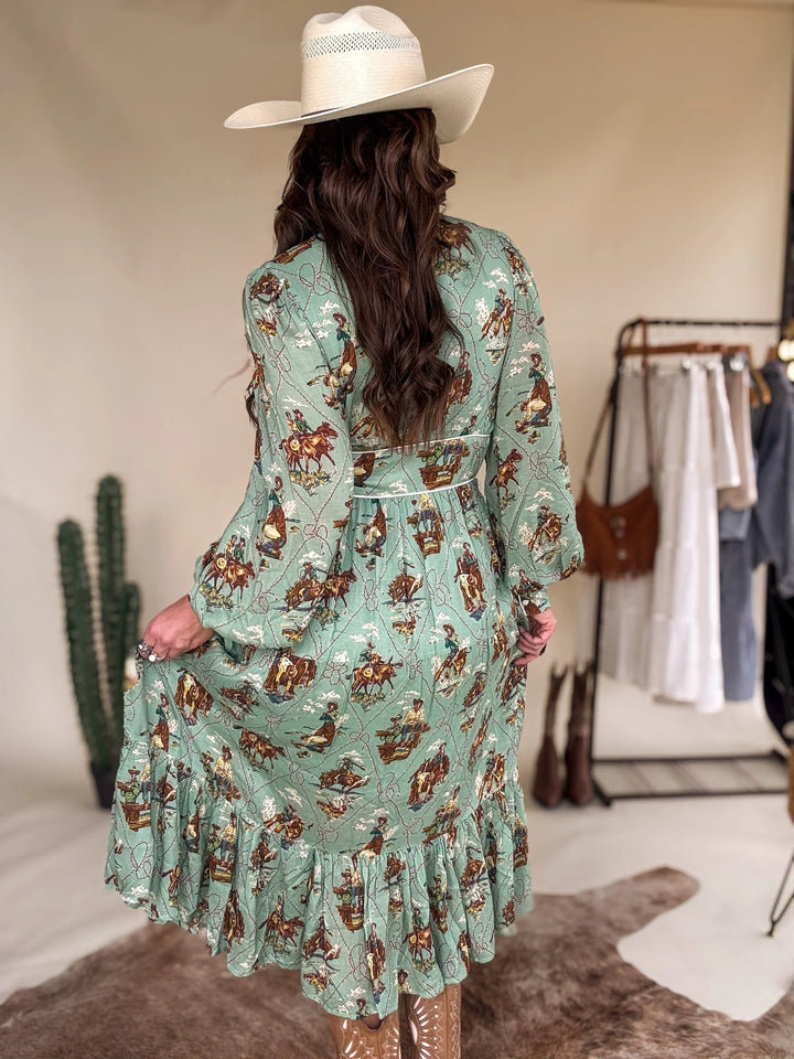 Woman in a cowgirl hat and sage green western print dress with ruffle hem, western boots