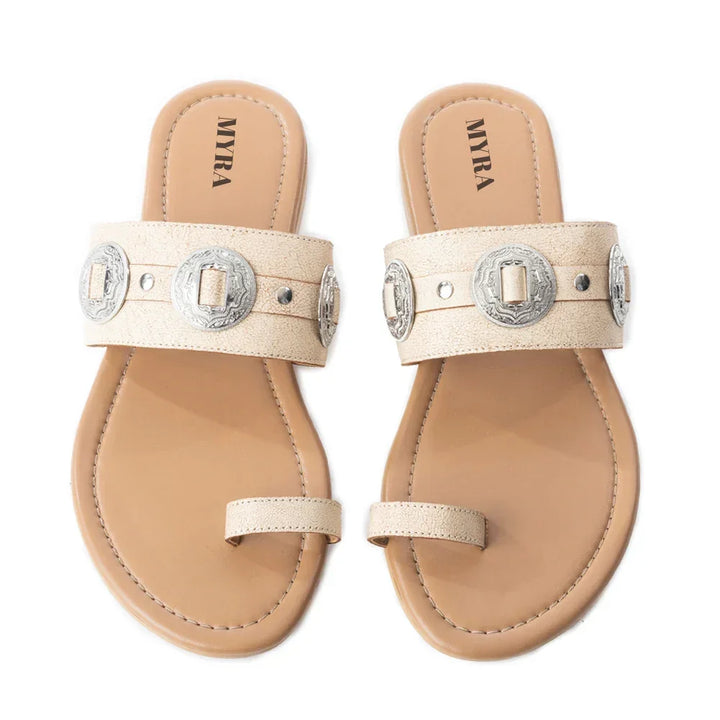 Pair of beige sandals with silver buckles on a white background