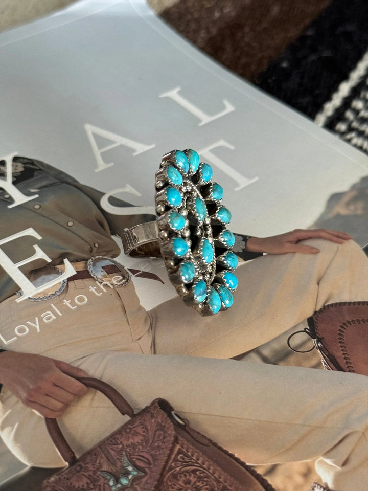 Oval turquoise statement ring with silver setting on western fashion magazine background