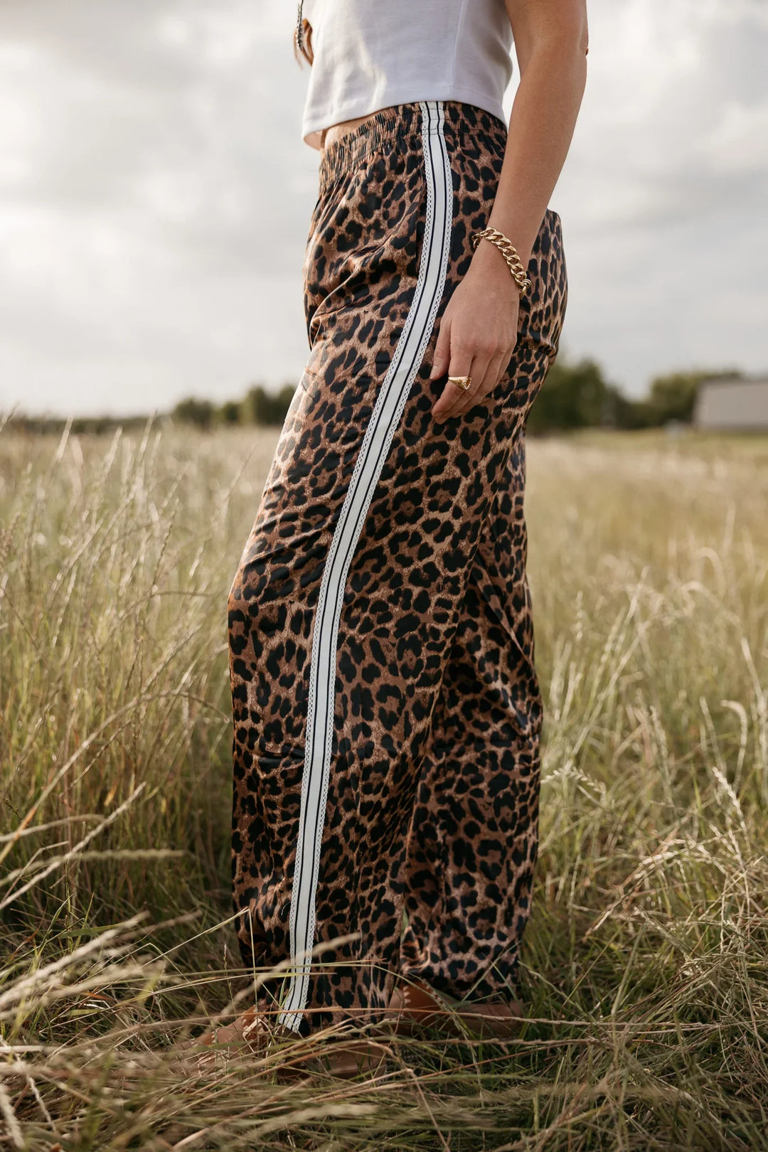 Person wearing a leopard print skirt with white stripes in a grassy field