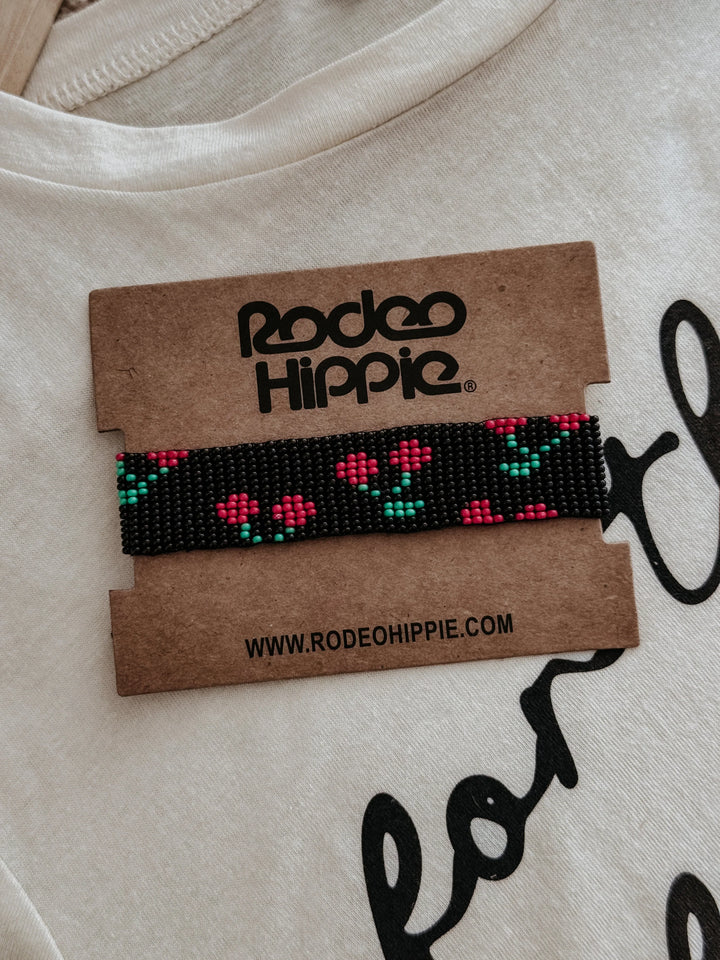 cherry Beaded bracelet on a Rodeo Hippie branded card with a beige background