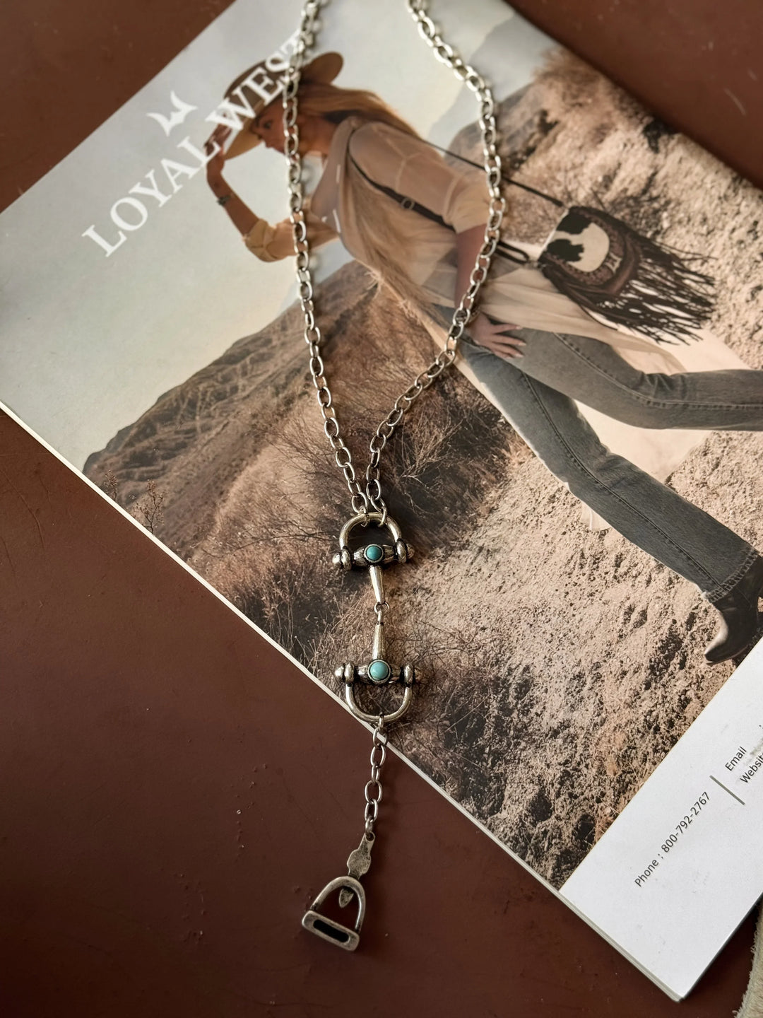 Silver necklace with horse bit pendant on a magazine cover