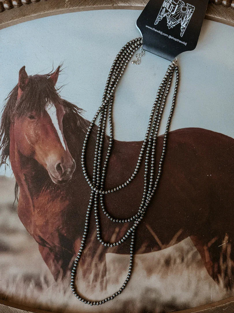 Necklace with a horse in the background