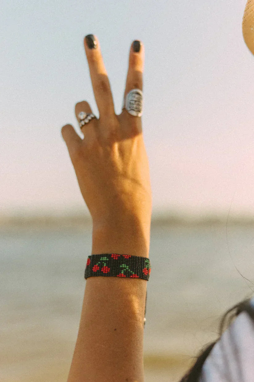 Hand with rings and a bracelet against a blurred natural background